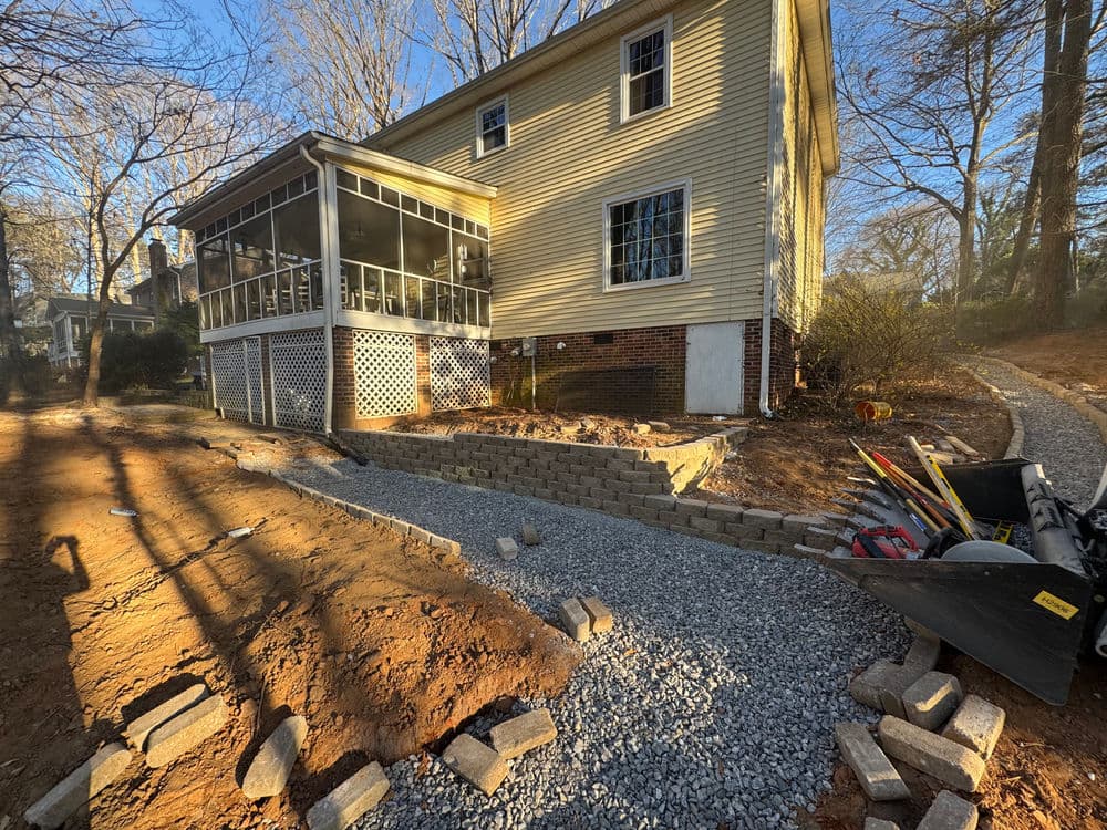 Home renovation project showing a newly constructed gravel pathway beside a house.